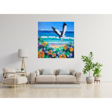 Load image into Gallery viewer, Colourful painting of a sea eagle flying over a beach with flowers and waves, displayed on a living room wall